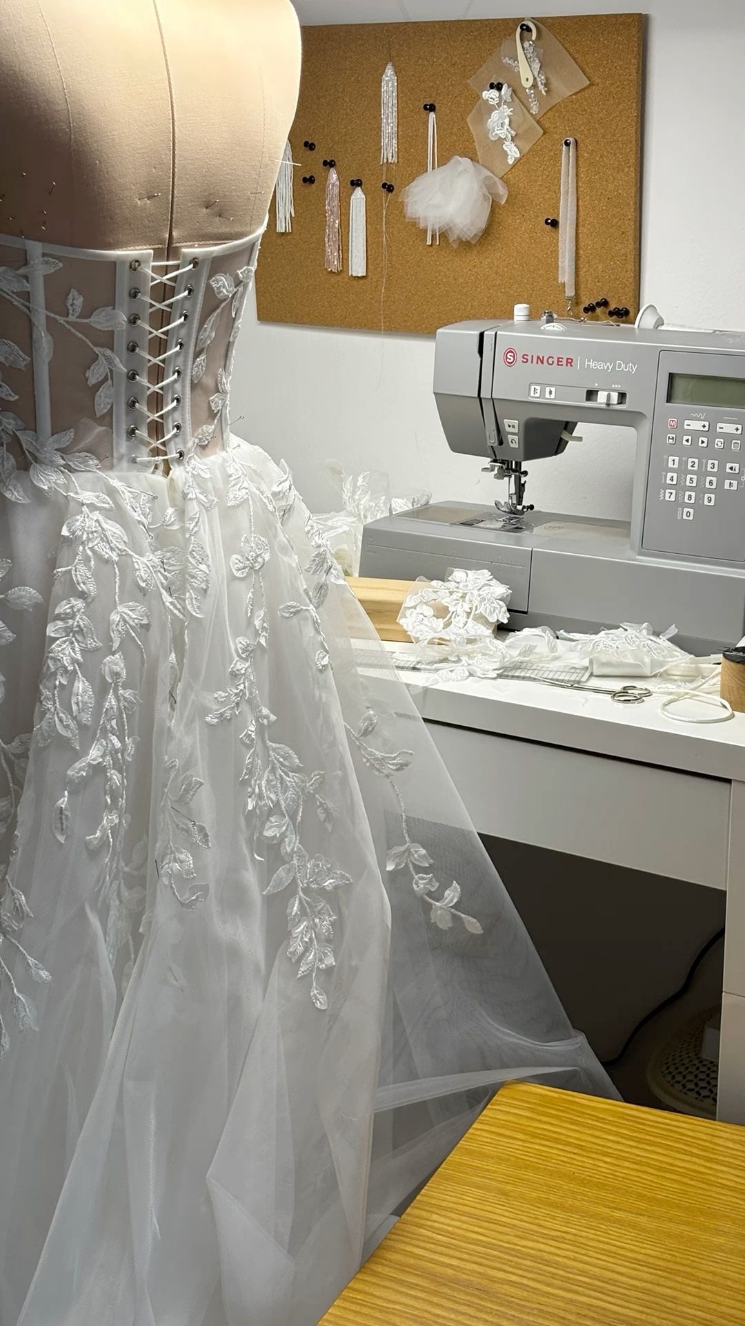 Wedding dress beside a sewing machine in the studio